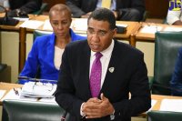 Prime Minister the Most Hon. Andrew Holness speaks in the House of Representatives on Tuesday (June 19). Seated at left is Minister without Portfolio in the Ministry of Finance and the Public Service, Hon. Fayval Williams.